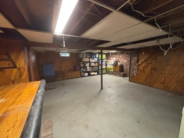 Cleared basement floor after junk removal, with shelving left in place