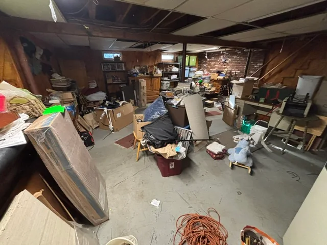 Furniture and boxes crowded into a basement before a JAM cleanout