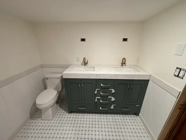 New bathroom vanity, toilet, and tile during the finishing stage